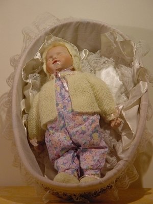 porseleinen baby pop Sara in mand met brocante